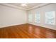 Spacious bedroom with hardwood floors, crown molding, recessed lights, and abundant natural light from three windows at 3333 N Hembree Rd, Marietta, GA 30062