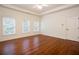 This primary bedroom features hardwood floors, a ceiling fan, and abundant natural light from three windows at 3333 N Hembree Rd, Marietta, GA 30062