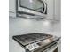 Close up view of a stainless steel stove, range hood, and tile backsplash at 3352 Cranston Ln, Kennesaw, GA 30144