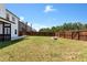 A large, fenced backyard featuring a fire pit and ample room for outdoor activities at 4171 Towncastle Ln, Buford, GA 30518