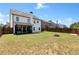 Spacious backyard featuring a fire pit, enclosed patio, and wooden fence for added privacy at 4171 Towncastle Ln, Buford, GA 30518