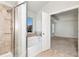 Bathroom boasts glass shower and a soaking tub, illuminated by a window with neighborhood views at 4171 Towncastle Ln, Buford, GA 30518