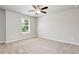This bedroom is bright with natural light and features a ceiling fan and neutral carpet at 4171 Towncastle Ln, Buford, GA 30518