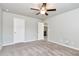 An airy bedroom boasts neutral carpet, a ceiling fan and access to other rooms via white doors at 4171 Towncastle Ln, Buford, GA 30518