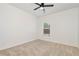 Bright bedroom with neutral carpet, ceiling fan, and a large window allowing natural light at 4171 Towncastle Ln, Buford, GA 30518