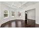 Elegant dining room with coffered ceilings, wainscoting, dark hardwood floors, and large windows at 4171 Towncastle Ln, Buford, GA 30518