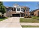Inviting two-story brick and white home with a two-car garage and a well-manicured front lawn at 4171 Towncastle Ln, Buford, GA 30518
