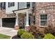 Charming entryway with brick columns, lush landscaping, and a black front door at 4171 Towncastle Ln, Buford, GA 30518