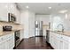 Bright kitchen with white cabinets, stainless steel appliances, and a granite countertop at 4171 Towncastle Ln, Buford, GA 30518