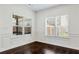 Bright living room with dark hardwood floors and large windows allowing ample natural light to enter at 4171 Towncastle Ln, Buford, GA 30518