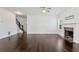Open-concept living room with dark hardwood floors, fireplace, and staircase access at 4171 Towncastle Ln, Buford, GA 30518