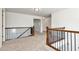 An open loft area with neutral carpeting, wooden railings, and natural light from nearby windows at 4171 Towncastle Ln, Buford, GA 30518