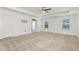 Expansive main bedroom featuring plush carpet, tray ceilings, and an abundance of natural light from large windows at 4171 Towncastle Ln, Buford, GA 30518