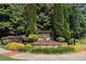 Beautifully landscaped community entrance sign with lush greenery and colorful flowers at 4171 Towncastle Ln, Buford, GA 30518
