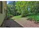 View of a backyard featuring a lush lawn and mature landscaping at 752 Roxboro Trce, Lawrenceville, GA 30044
