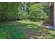 Backyard with trees and a retaining wall, creating a tranquil and private outdoor space at 752 Roxboro Trce, Lawrenceville, GA 30044