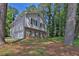 View of a two story home featuring a brick facade and light gray siding surrounded by trees at 752 Roxboro Trce, Lawrenceville, GA 30044