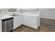 Well-lit kitchen features white cabinets, stainless steel dishwasher, and wood-look flooring at 752 Roxboro Trce, Lawrenceville, GA 30044