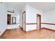 Hallway with hardwood floors, neutral paint, and trim throughout leading to brick fireplace at 98 Country Acres Ct, Mcdonough, GA 30253