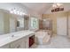 Bathroom featuring tiled floors, vanities, soaking tub, and shower at 4975 Duncans Lake Dr, Buford, GA 30519