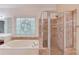 Bathroom with a tile shower, soaking tub, and stained glass window at 4975 Duncans Lake Dr, Buford, GA 30519