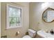 Powder room features a sink, toilet, mirror, and a window at 4975 Duncans Lake Dr, Buford, GA 30519