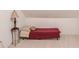 Bedroom featuring red cot, accent table, and neutral paint at 4975 Duncans Lake Dr, Buford, GA 30519