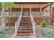Inviting front porch with stained wood columns and railings and access to brick pathway at 4975 Duncans Lake Dr, Buford, GA 30519