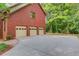 Three car garage with ample parking space, next to the lush green scenery at 4975 Duncans Lake Dr, Buford, GA 30519