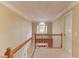 Bright hallway featuring wood railing, neutral walls, and a window view at 4975 Duncans Lake Dr, Buford, GA 30519