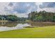 Serene lake view with a dock, surrounded by lush greenery and distant homes, offering a peaceful escape for residents at 4975 Duncans Lake Dr, Buford, GA 30519