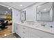 Bright bathroom featuring double sinks, white cabinets, modern fixtures and a view into the bedroom at 6851 Roswell Rd # E4, Atlanta, GA 30328