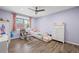 Bedroom featuring pale purple walls, wood floors, with a view of a window at 6851 Roswell Rd # E4, Atlanta, GA 30328
