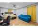 Bedroom with hardwood floors, ceiling fan, yellow accents, and a blue couch at 6851 Roswell Rd # E4, Atlanta, GA 30328