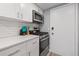 Well-lit kitchen showcasing stainless steel appliances, white cabinetry, and stone countertops at 6851 Roswell Rd # E4, Atlanta, GA 30328