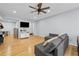 Cozy living room with hardwood floors, gray sofa, and a television mounted on the wall at 6851 Roswell Rd # E4, Atlanta, GA 30328