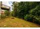 Lawn backyard view featuring trees, bushes and small deck at 1045 Paper Creek Dr, Lawrenceville, GA 30046
