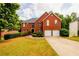 Charming two-story brick home with a well-manicured lawn and an attached two-car garage at 1045 Paper Creek Dr, Lawrenceville, GA 30046