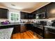 The well-equipped kitchen includes stainless steel appliances, dark cabinetry and granite countertops on hardwood floors at 1045 Paper Creek Dr, Lawrenceville, GA 30046