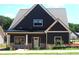 Beautiful two-story home featuring dark siding, white trim, and a covered front porch at 135 Old Alabama Rd, Emerson, GA 30137