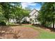 Stately home nestled among mature trees features a well-maintained lawn and mulched landscape with a symmetrical facade at 4223 N Mountain Ne Rd, Marietta, GA 30066