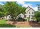 Stately home featuring lush landscaping, mulched beds and a symmetrical facade under a bright blue sky at 4223 N Mountain Ne Rd, Marietta, GA 30066