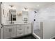 Modern bathroom with double vanity, white cabinets, quartz countertops, and a tiled shower at 1790 Shirley Sw St, Atlanta, GA 30310