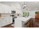 Updated kitchen boasts a large island, white cabinets, stainless steel appliances, and hardwood flooring at 1790 Shirley Sw St, Atlanta, GA 30310