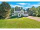 Two-story home featuring a covered front porch, attached garage, well-manicured lawn and mature shade trees at 185 Waverly Walk, Douglasville, GA 30134