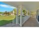 Covered front porch featuring white railings and columns with an expansive green front lawn at 185 Waverly Walk, Douglasville, GA 30134