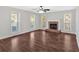 Inviting living room with a cozy brick fireplace, hardwood floors, and multiple windows for natural light at 185 Waverly Walk, Douglasville, GA 30134