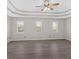 Bright main bedroom features large windows for ample natural light, gray flooring, and a ceiling fan at 185 Waverly Walk, Douglasville, GA 30134