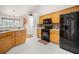 Bright kitchen features light wood cabinets, black appliances, and stylish backsplash at 758 Beranda Cir, Douglasville, GA 30134