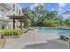 Inviting swimming pool with lounge chairs, a covered patio, and mature trees at 775 Juniper St # 212, Atlanta, GA 30308